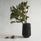The Collective Pumice Vase, a matte black textured vase holding eucalyptus branches