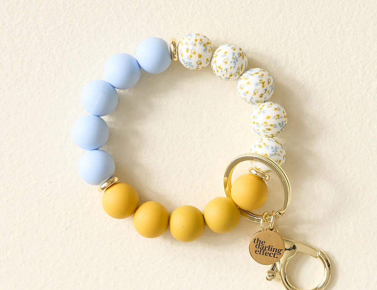 The Darling Effect Hands-Free Keychain Wristlet in Country Cottage, blue, floral and mustard silicone beads with a gold clasp
