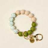 The Darling Effect Hands-Free Keychain Wristlet in Olive Branch, tan, floral and olive silicone beads with a gold clasp