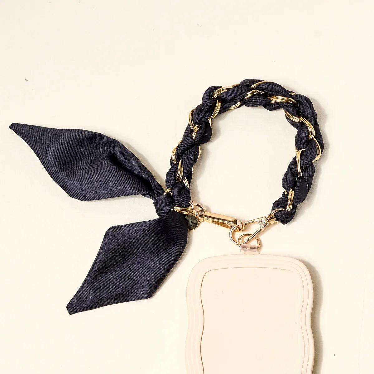 The Darling Effect Phone Scarf in Black attached to a cream phone case