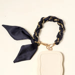 The Darling Effect Phone Scarf in Black attached to a cream phone case