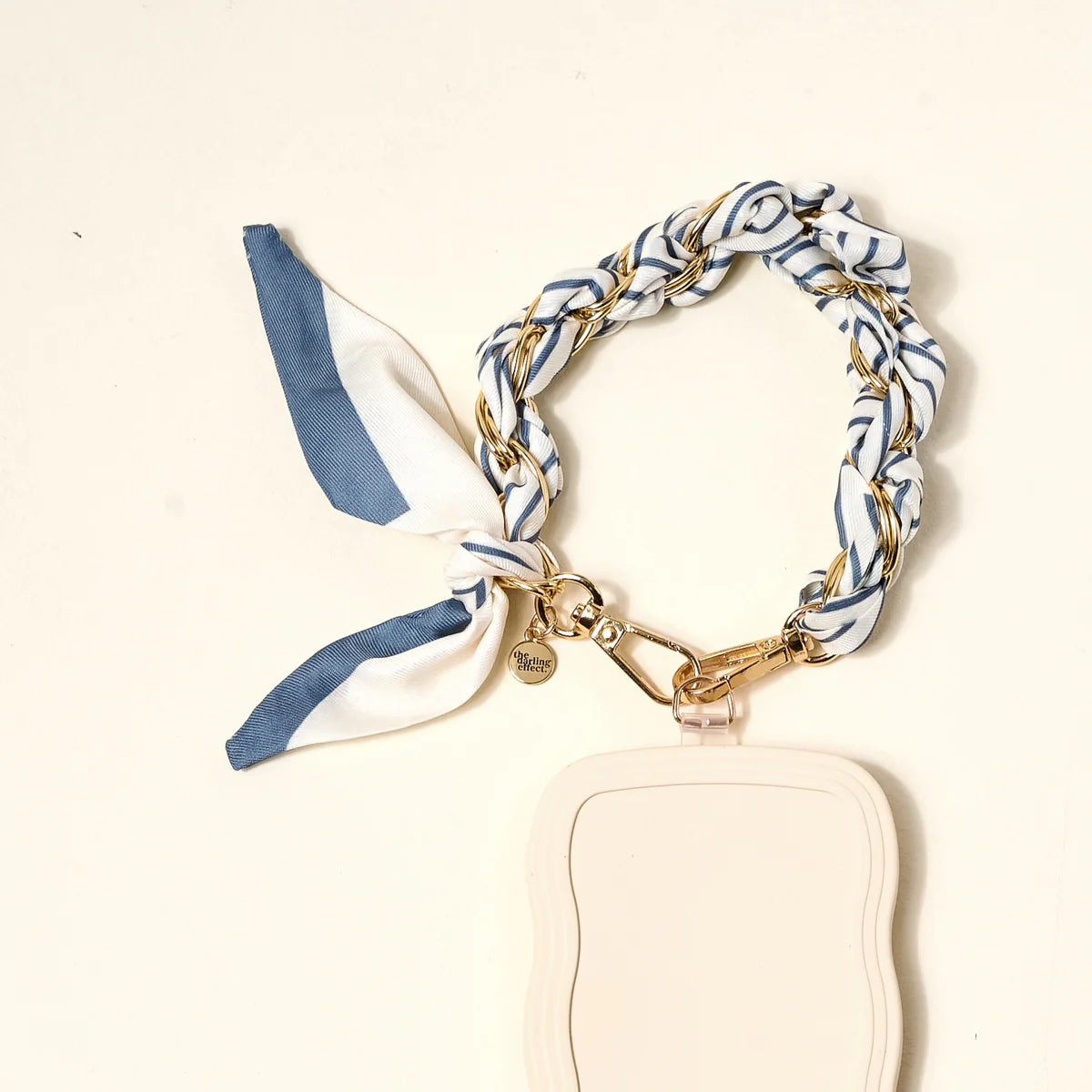 The Darling Effect Phone Scarf in Bluebell Stripe attached to a cream phone case
