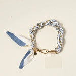 The Darling Effect Phone Scarf in Bluebell Stripe, a blue and white striped satin scarf on a gold chain wristlet