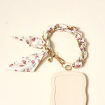 The Darling Effect Phone Scarf in Garden Party attached to a cream phone case