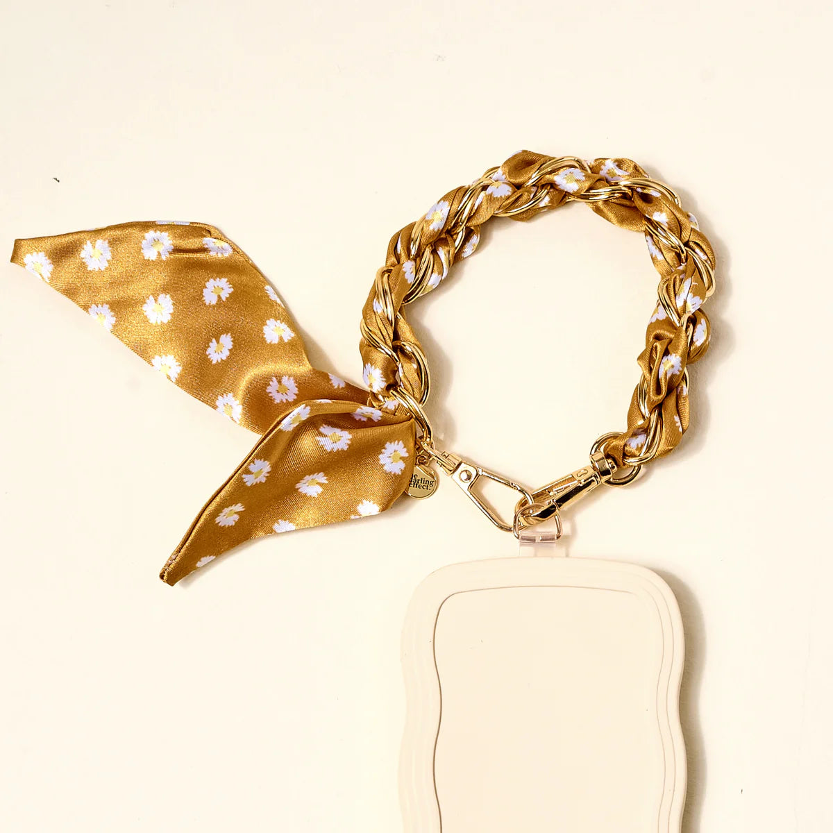 The Darling Effect Phone Scarf in Honey Blossom attached to a cream phone case