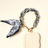 The Darling Effect Phone Scarf in Monochrome Muse attached to a cream phone case