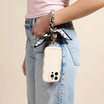 Woman in jeans carrying a phone on her wrist with The Darling Effect Phone Scarf in Monochrome Muse