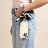 Woman in jeans carrying a phone on her wrist with The Darling Effect Phone Scarf in Monochrome Muse