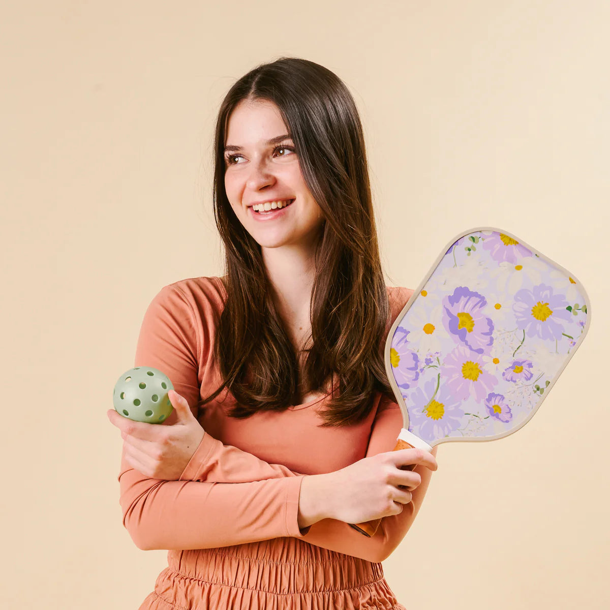 Smiling woman holding The Darling Effect Pickleball Paddle in Bouquet Beauty Purple and a green ball