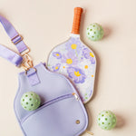 The Darling Effect Pickleball Paddle in Bouquet Beauty Purple with a lavender case and green pickleballs