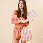 Woman holding The Darling Effect Pickleball Paddle in Petal Parade Pink with its striped case