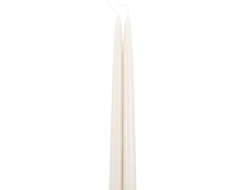 The Floral Society 18-inch Dipped Taper Candles in Parchment, a pair of ivory tapers hanging by their wick on white