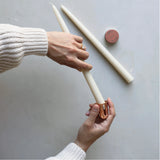 Hands sharpening a cream taper candle with The Floral Society Copper Candle Sharpener