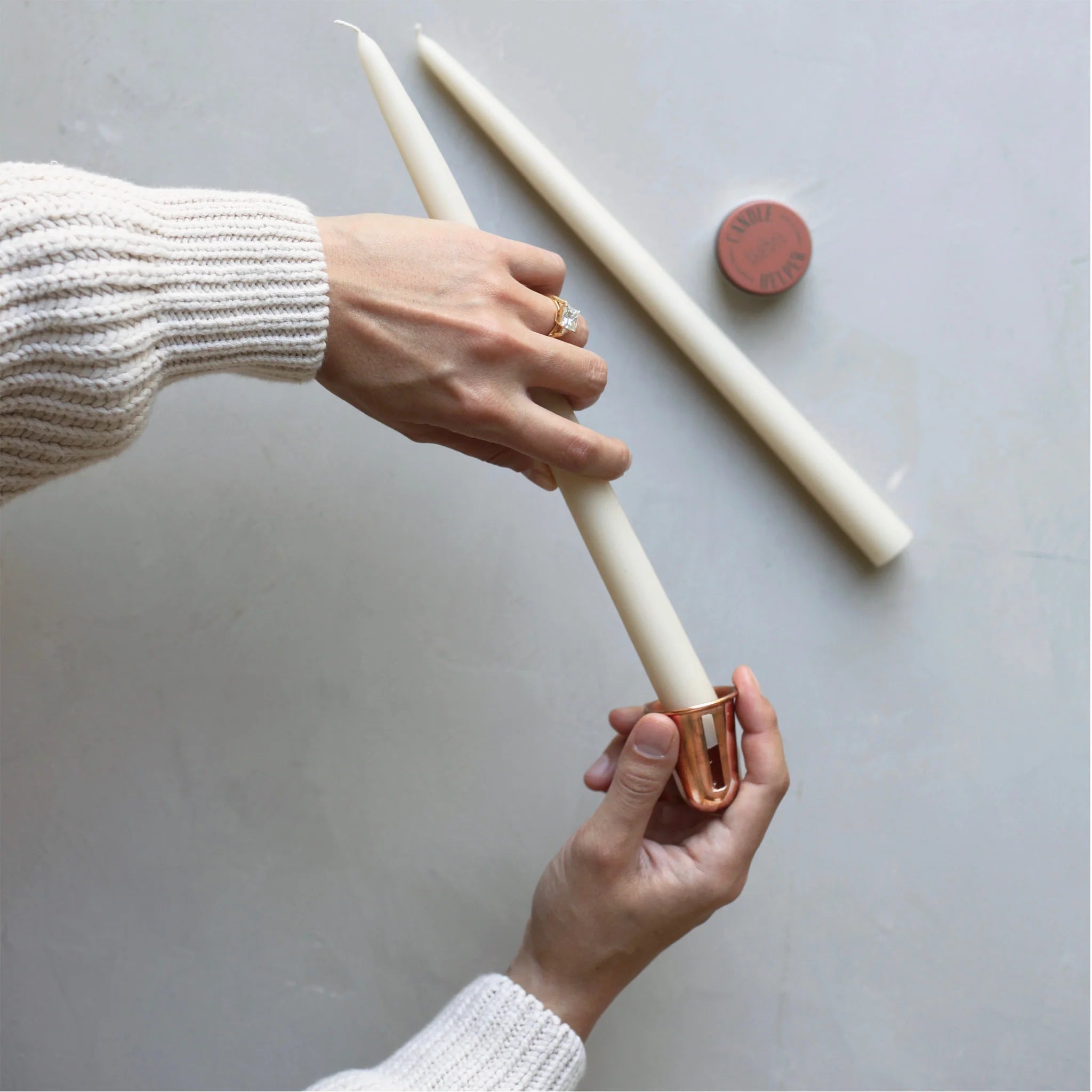 Hands sharpening a cream taper candle with The Floral Society Copper Candle Sharpener
