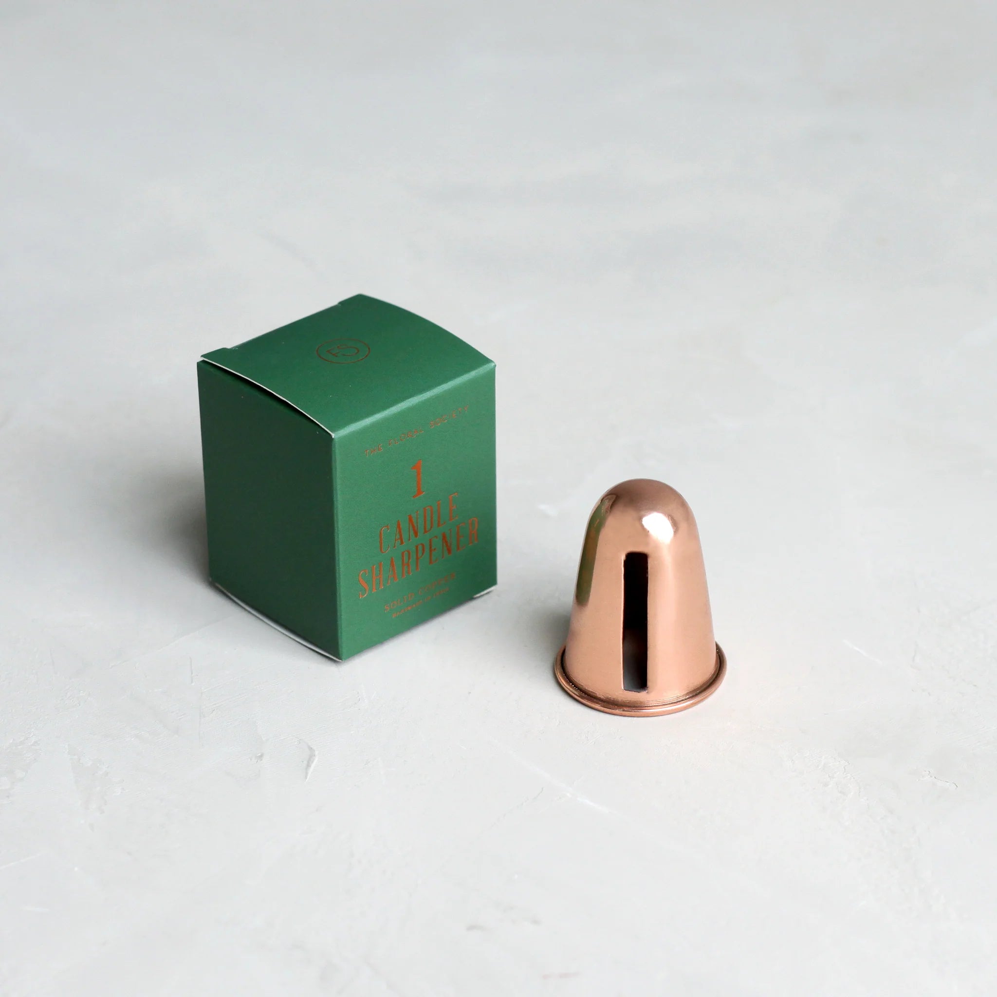 The Floral Society Copper Candle Sharpener beside its small green gift box