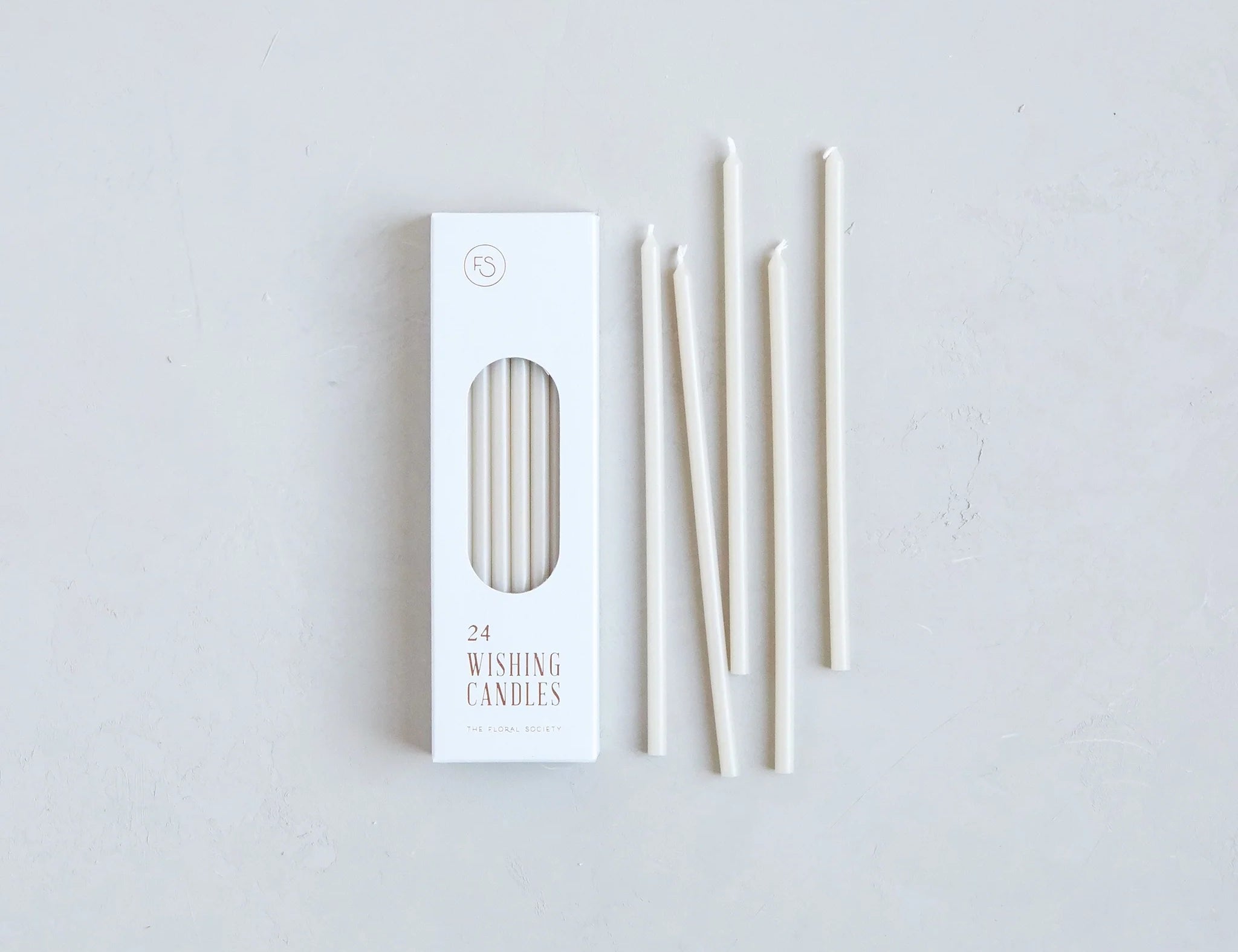 The Floral Society Wishing Candles in Parchment, thin cream taper candles beside their white box