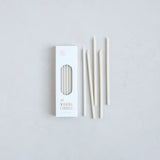 The Floral Society Wishing Candles in Parchment, thin cream taper candles beside their white box