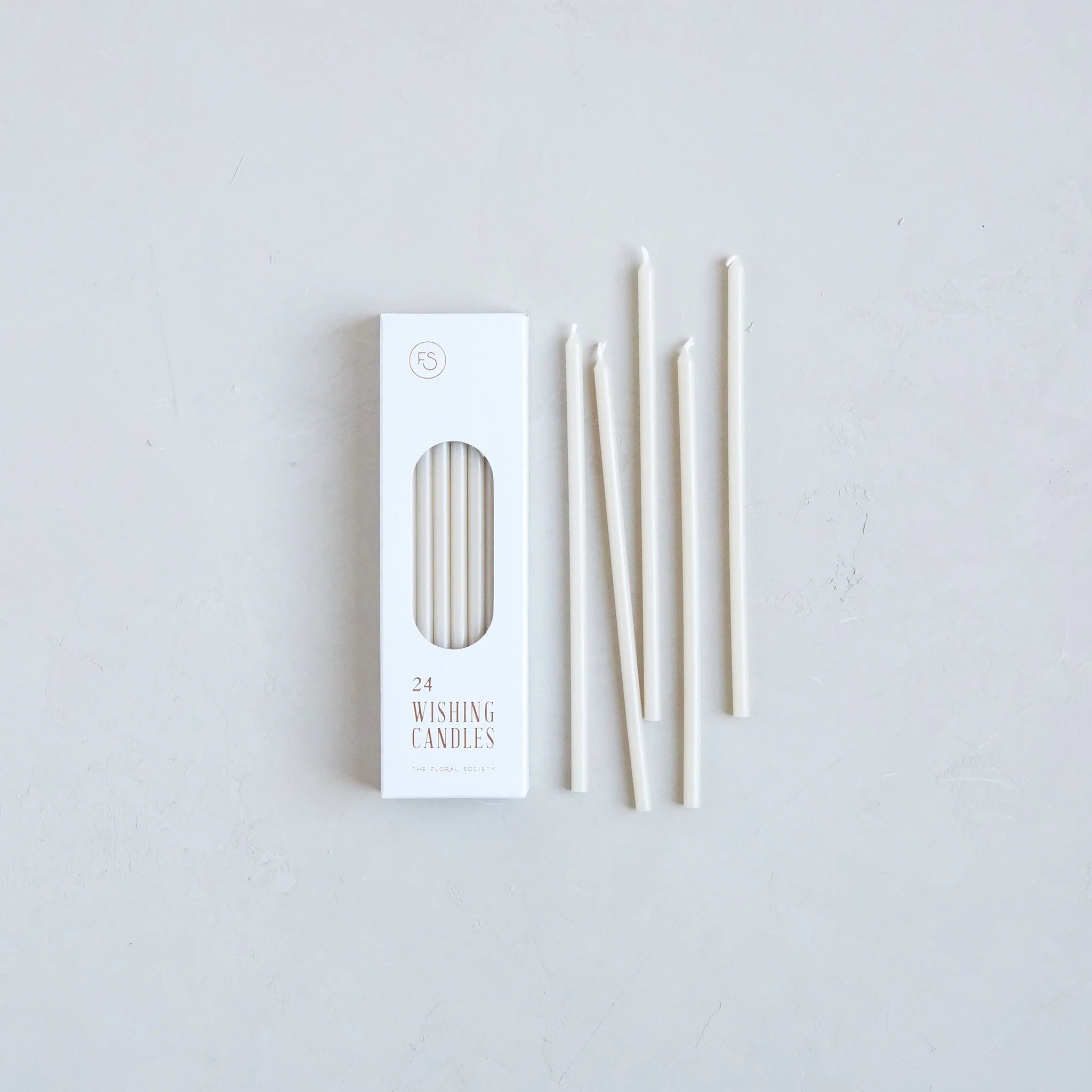 The Floral Society Wishing Candles in Parchment, thin cream taper candles beside their white box