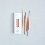 The Floral Society Wishing Candles in Petal, thin blush pink taper candles beside their white box