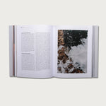 The Gospels book open to a text page with a photo of crashing waves