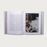 The Gospels book open to a text page with a photo of crashing waves
