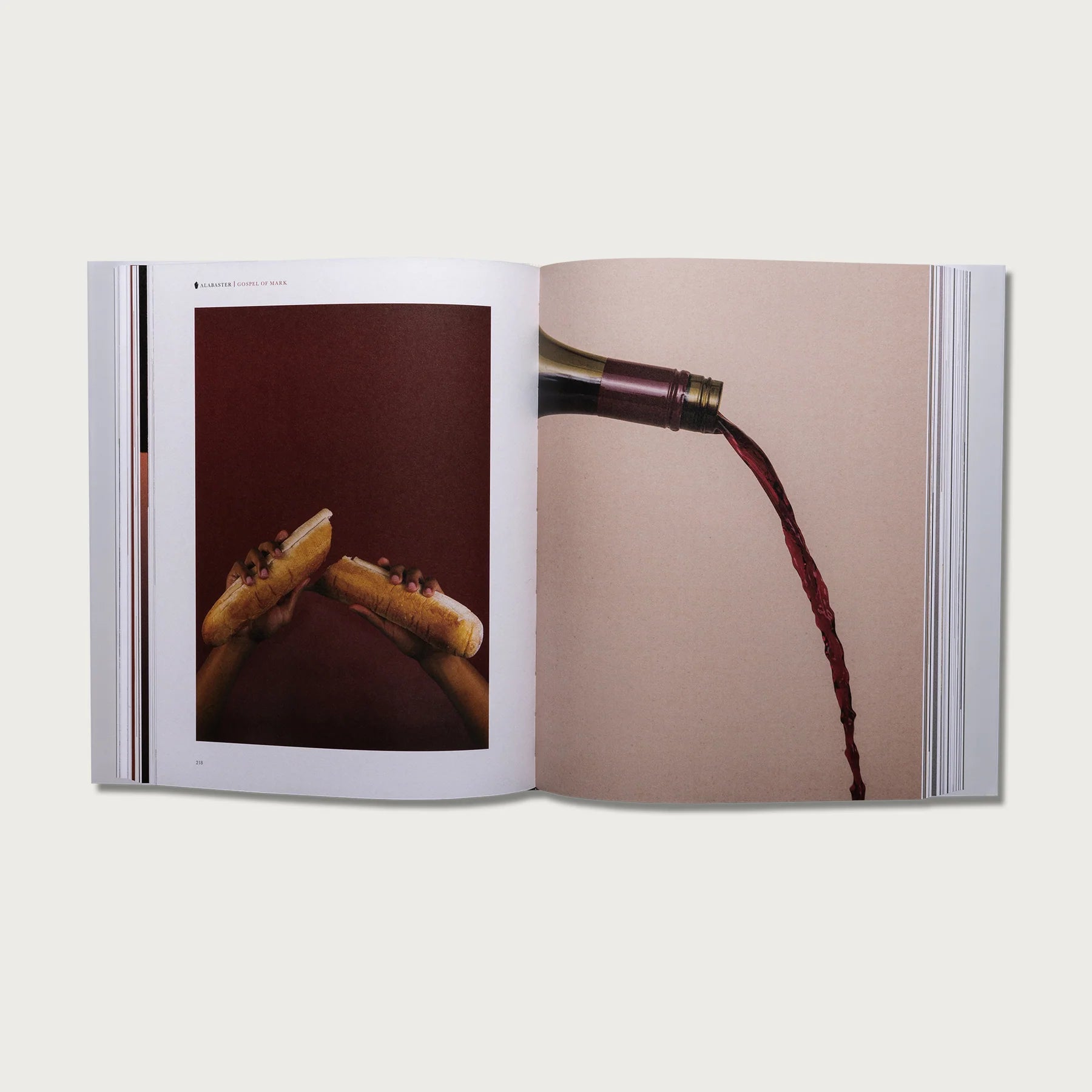 The Gospels book open to a spread with photos of a hand and pouring wine