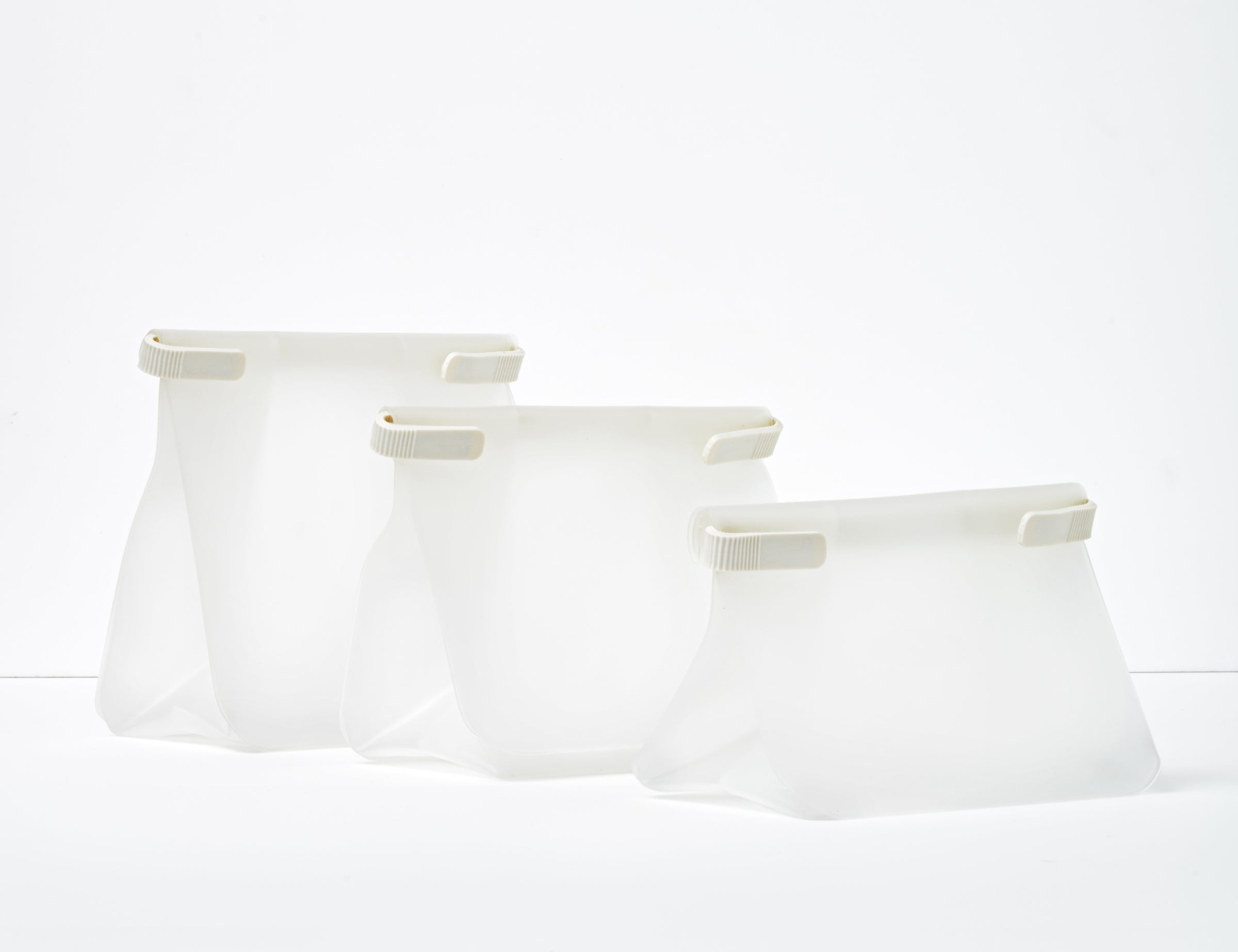 W&P Roll Tight Freezer Storage Bag Set, three clear silicone bags in graduated sizes standing open