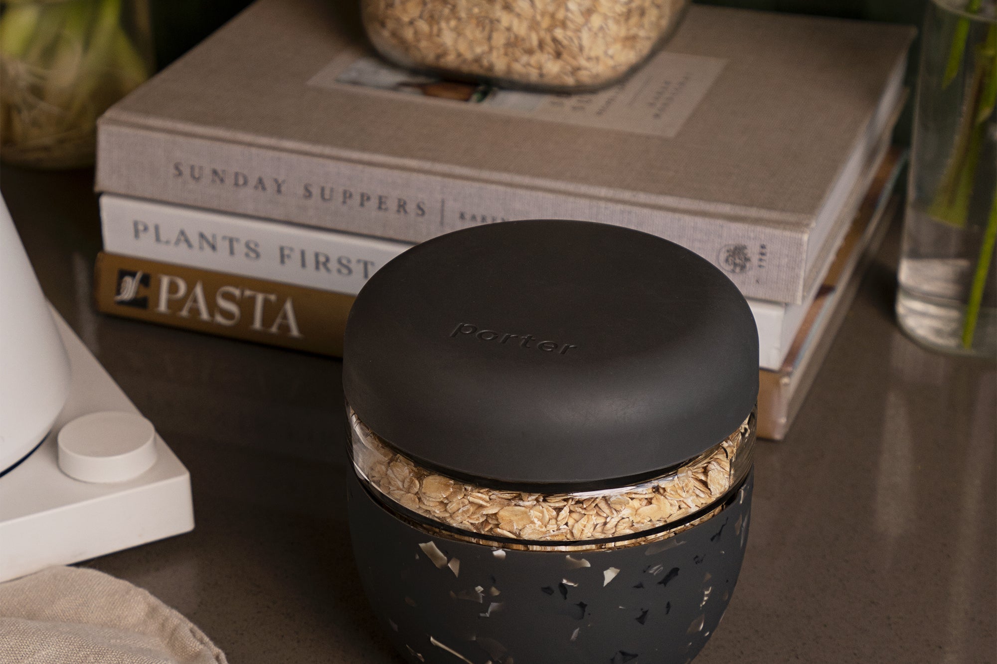 W&P Seal Tight Bowl in Terrazzo Charcoal filled with granola on a kitchen counter beside cookbooks