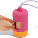 Wild One Poop Bag Carrier in Cosmopolitan hot pink with an orange base, with a peach waste bag pulling out, on a white background