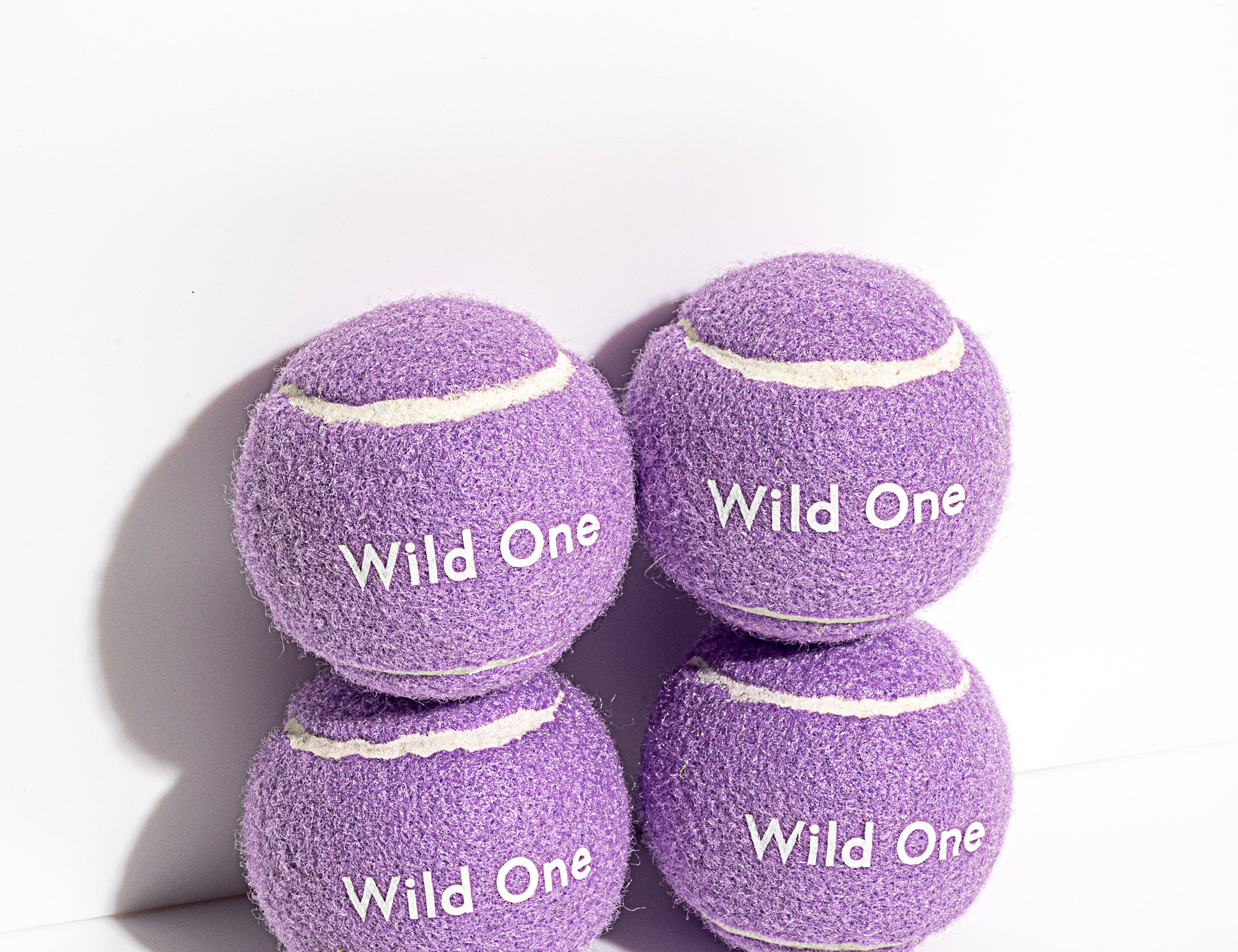 Wild One Tennis Balls in Lilac, four purple felt balls stacked with the Wild One logo