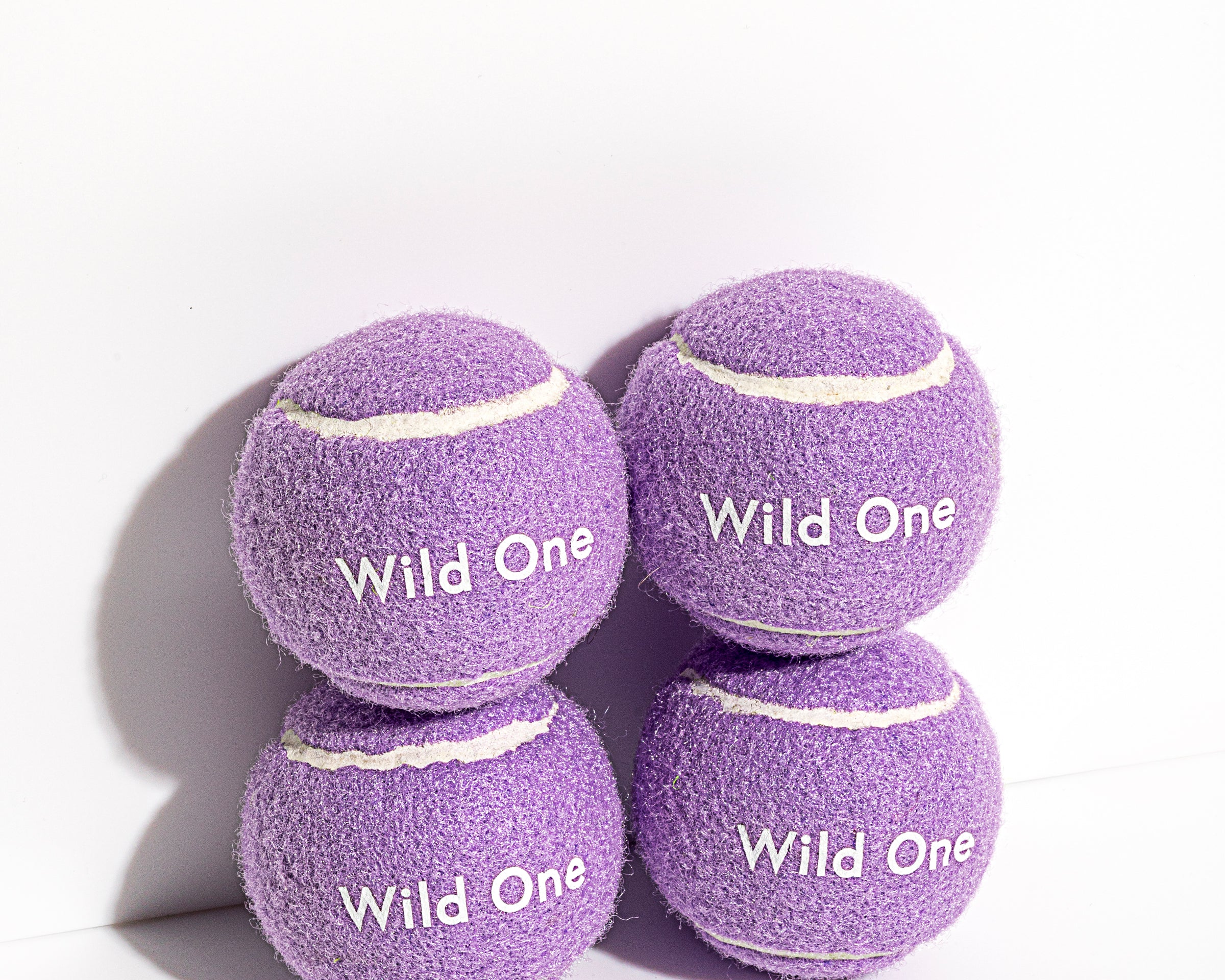 Wild One Tennis Balls in Lilac, four purple felt balls stacked with the Wild One logo