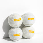 Wild One Tennis Balls in White, four white felt balls stacked with an orange Wild One logo